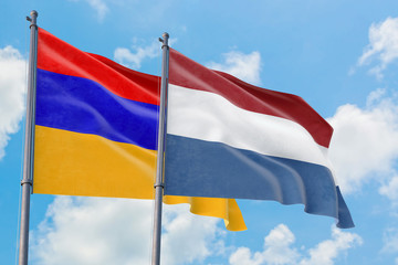 Fototapeta na wymiar Netherlands and Armenia flags waving in the wind against white cloudy blue sky together. Diplomacy concept, international relations.