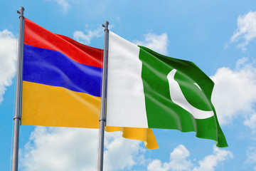 Pakistan and Armenia flags waving in the wind against white cloudy blue sky together. Diplomacy concept, international relations.