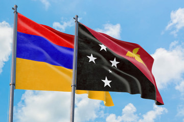 Papua New Guinea and Armenia flags waving in the wind against white cloudy blue sky together. Diplomacy concept, international relations.