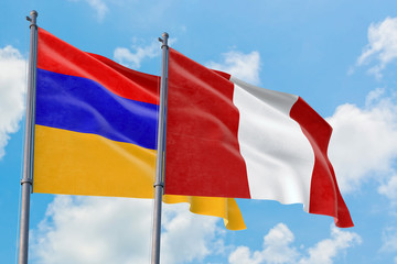 Peru and Armenia flags waving in the wind against white cloudy blue sky together. Diplomacy concept, international relations.