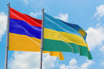 Rwanda and Armenia flags waving in the wind against white cloudy blue sky together. Diplomacy concept, international relations.