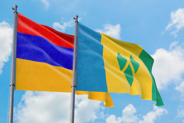 Saint Vincent And The Grenadines and Armenia flags waving in the wind against white cloudy blue sky together. Diplomacy concept, international relations.