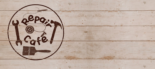 Repair Cafe logo on wooden board,  header or background with copyspace, consumer movement to repair household items to reduce waste and support a sustainable zero waste lifestyle