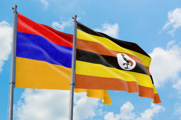 Uganda and Armenia flags waving in the wind against white cloudy blue sky together. Diplomacy concept, international relations.