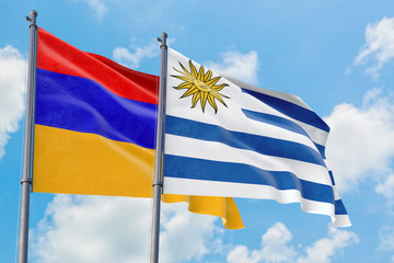 Uruguay and Armenia flags waving in the wind against white cloudy blue sky together. Diplomacy concept, international relations.