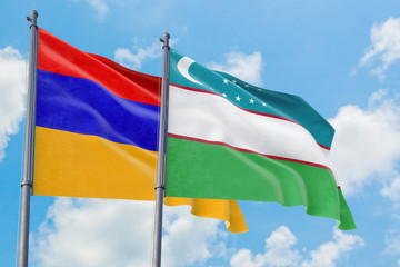 Uzbekistan and Armenia flags waving in the wind against white cloudy blue sky together. Diplomacy concept, international relations.