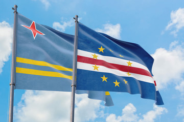 Cape Verde and Aruba flags waving in the wind against white cloudy blue sky together. Diplomacy concept, international relations.
