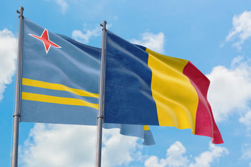 Chad and Aruba flags waving in the wind against white cloudy blue sky together. Diplomacy concept, international relations.