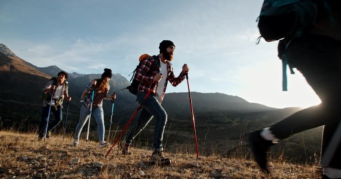 Four young people on hike adventure - Group of students trekking in mountains together, having a vacation - friendship, travel destination concept 4k footage