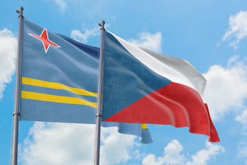 Czech Republic and Aruba flags waving in the wind against white cloudy blue sky together. Diplomacy concept, international relations.