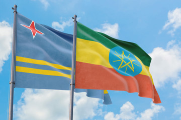 Ethiopia and Aruba flags waving in the wind against white cloudy blue sky together. Diplomacy concept, international relations.