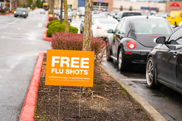 Free Flu Shots sign in parking lot outside of pharmacy.