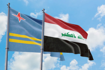 Iraq and Aruba flags waving in the wind against white cloudy blue sky together. Diplomacy concept,...