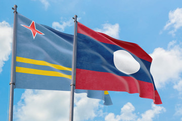 Laos and Aruba flags waving in the wind against white cloudy blue sky together. Diplomacy concept, international relations.