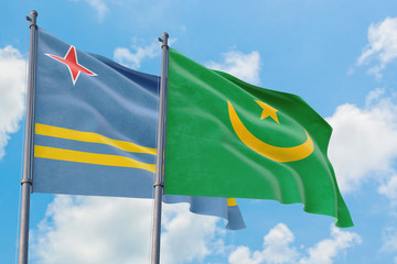 Mauritania and Aruba flags waving in the wind against white cloudy blue sky together. Diplomacy concept, international relations.