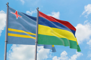 Mauritius and Aruba flags waving in the wind against white cloudy blue sky together. Diplomacy concept, international relations.