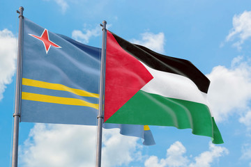 Palestine and Aruba flags waving in the wind against white cloudy blue sky together. Diplomacy concept, international relations.