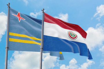 Paraguay and Aruba flags waving in the wind against white cloudy blue sky together. Diplomacy concept, international relations.