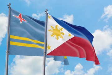 Philippines and Aruba flags waving in the wind against white cloudy blue sky together. Diplomacy concept, international relations.
