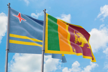 Sri Lanka and Aruba flags waving in the wind against white cloudy blue sky together. Diplomacy concept, international relations.