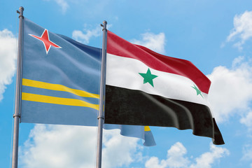 Syria and Aruba flags waving in the wind against white cloudy blue sky together. Diplomacy concept,...