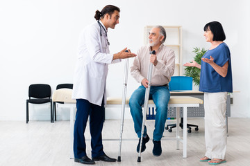 Old couple visiting young male doctor