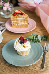 Cupcake with white cream and berries on the table
