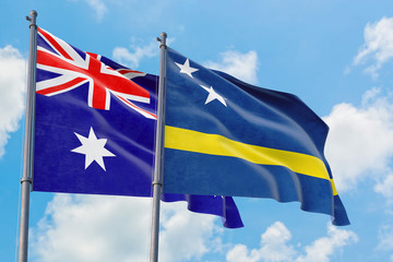 Curacao and Australia flags waving in the wind against white cloudy blue sky together. Diplomacy concept, international relations.