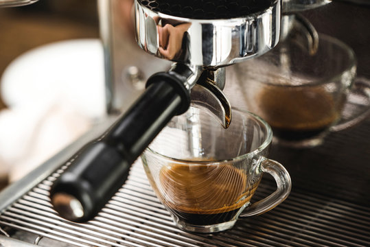 Coffee maker machine brewing espresso shot in clear glass cup