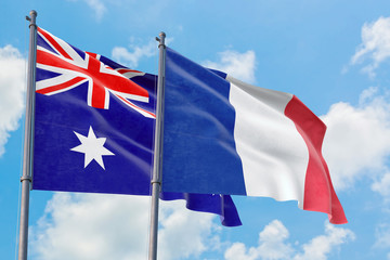 France and Australia flags waving in the wind against white cloudy blue sky together. Diplomacy concept, international relations.