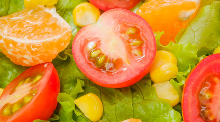 Close up of red tomato on green salad.Mix salad.vegetarian concept.orange and corn.healthy food