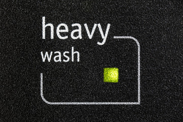 Macro close up photograph of heavy wash indicator light on dishwasher machine.  