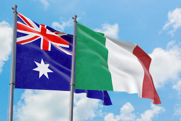 Italy and Australia flags waving in the wind against white cloudy blue sky together. Diplomacy concept, international relations.