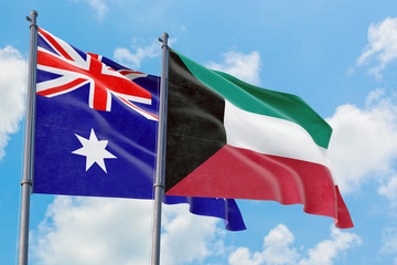 Fototapeta premium Kuwait and Australia flags waving in the wind against white cloudy blue sky together. Diplomacy concept, international relations.