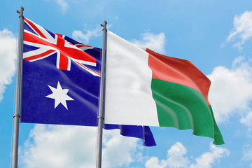 Madagascar and Australia flags waving in the wind against white cloudy blue sky together. Diplomacy concept, international relations.