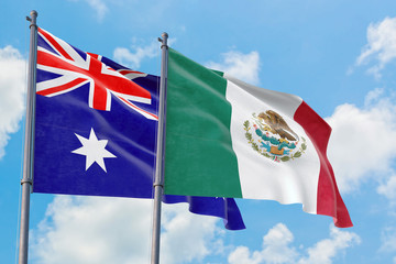 Mexico and Australia flags waving in the wind against white cloudy blue sky together. Diplomacy concept, international relations.