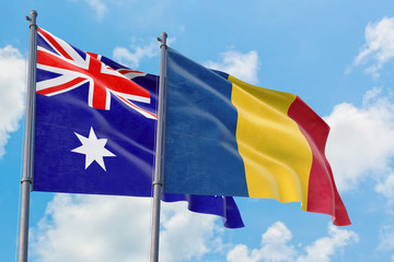 Romania and Australia flags waving in the wind against white cloudy blue sky together. Diplomacy concept, international relations.