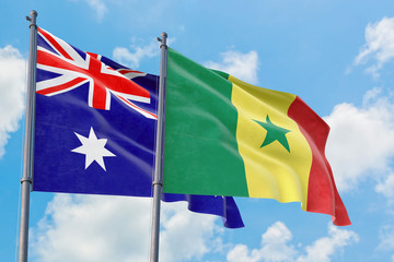 Senegal and Australia flags waving in the wind against white cloudy blue sky together. Diplomacy concept, international relations.