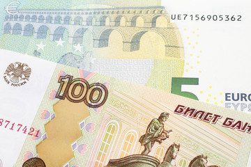 A close up image of a one hundred Russian ruble bank note close up with a five Euro bank note