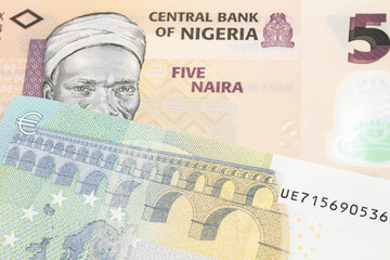 An orange five naira note from Nigeria with a five euro German bank note close up in macro