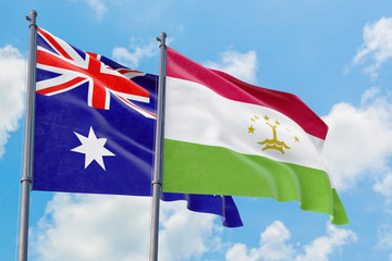 Tajikistan and Australia flags waving in the wind against white cloudy blue sky together. Diplomacy concept, international relations.