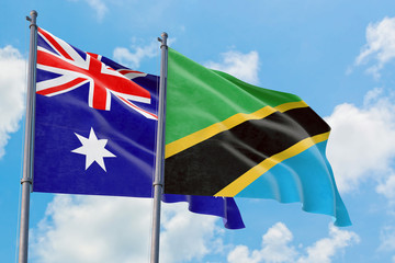 Fototapeta premium Tanzania and Australia flags waving in the wind against white cloudy blue sky together. Diplomacy concept, international relations.