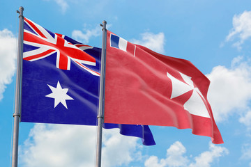 Wallis And Futuna and Australia flags waving in the wind against white cloudy blue sky together. Diplomacy concept, international relations.