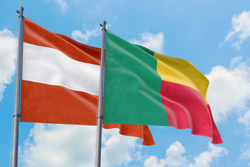 Benin and Austria flags waving in the wind against white cloudy blue sky together. Diplomacy concept, international relations.