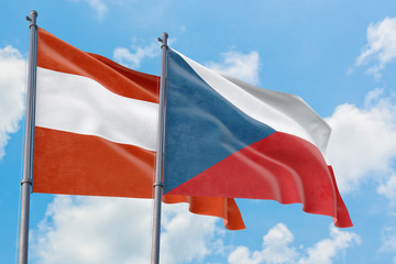 Czech Republic and Austria flags waving in the wind against white cloudy blue sky together. Diplomacy concept, international relations.