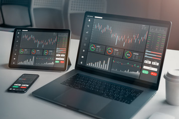 Stock exchange market concept, laptop and tablet, smartphone on the table with graphs analysis candle line in office room, diagrams on screen. - obrazy, fototapety, plakaty