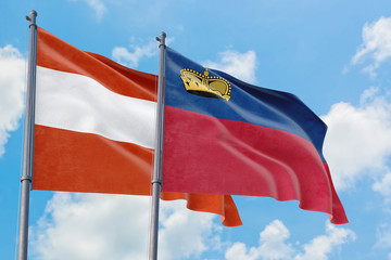Liechtenstein and Austria flags waving in the wind against white cloudy blue sky together. Diplomacy concept, international relations.