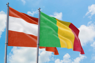 Mali and Austria flags waving in the wind against white cloudy blue sky together. Diplomacy concept, international relations.