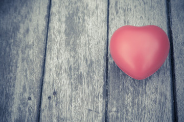 Naklejka na ściany i meble Red heart on wooden table