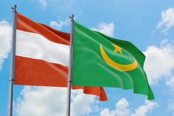 Mauritania and Austria flags waving in the wind against white cloudy blue sky together. Diplomacy concept, international relations.